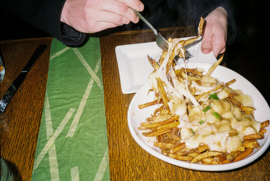 Direct flash film photo of plate of poutine at restaurant