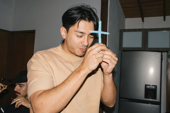 man holding cross shaped joint cannabis symbolic