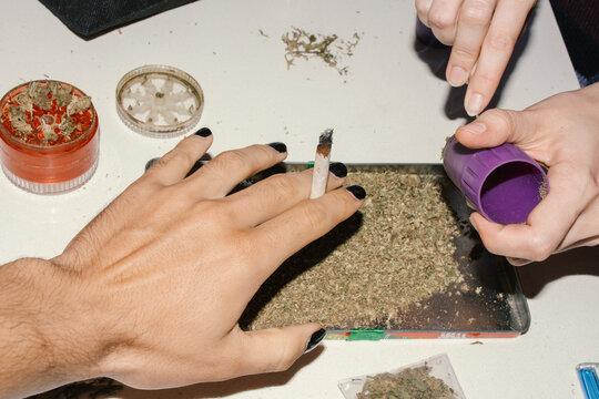 marijuana tray with lit joint and rolling tools on table 