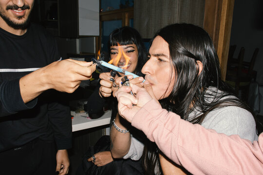 Friends lighting cross joint together  and laughing 