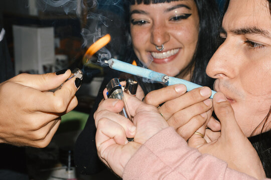 Friends lighting cross joint together  and laughing 