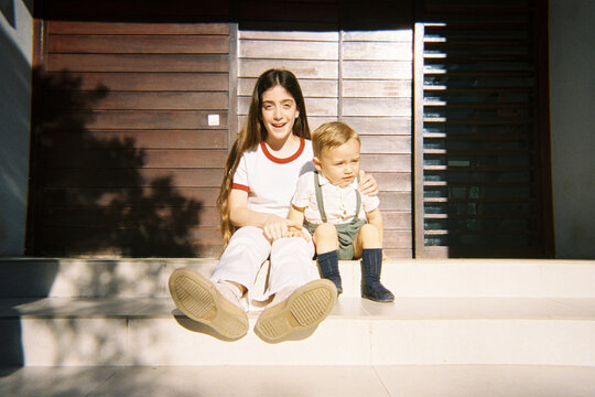 Cousins Sitting at Home Entrance
