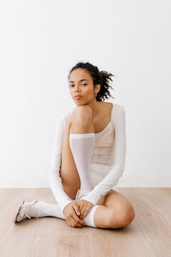 Young model posing on floor with white socks and sandals