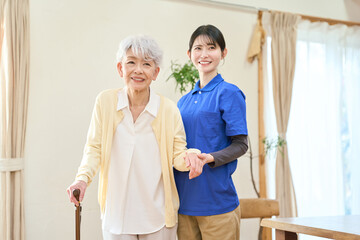 Fototapeta premium 訪問介護で歩行介助をするアジア人介護士