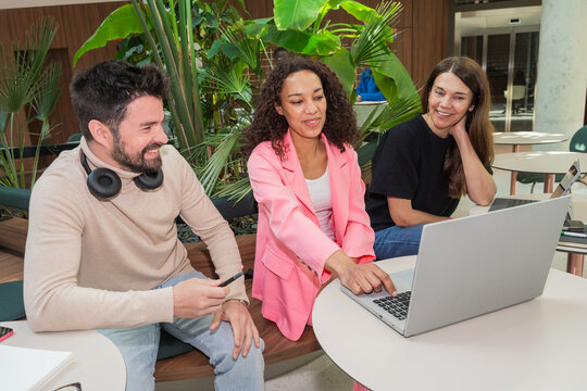 Laughing Coworkers Collaborating On Laptop