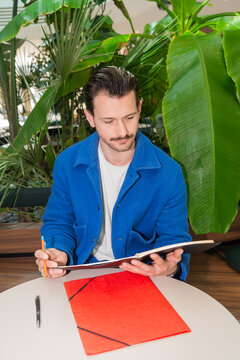 Man Writing In Notebook Indoors