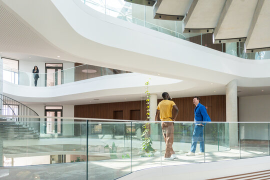 Business Chat On Upper Walkway In The Office.