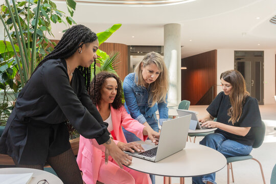 Focused Women Collaborating On Laptops

