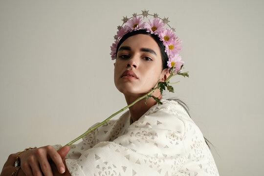 Nonbinary person wearing elegant white lace dress  and flower crown