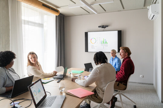 Conversation At Office Meeting With Graph Presentation