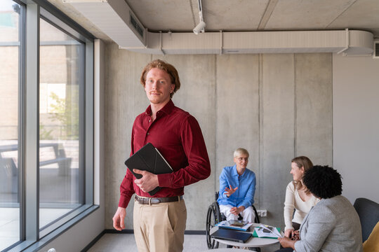 Confident Male Leader with Team in Background