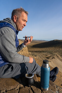 Man sending voice mail message on a cliff
