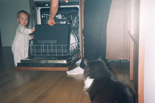 Toddler at Open Dishwasher Helping Dad With Domestic Chores - film 