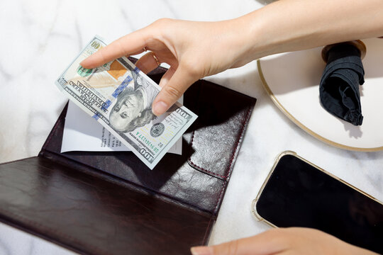 A young woman pays a bill in a restaurant