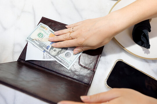 A young woman pays a bill in a restaurant