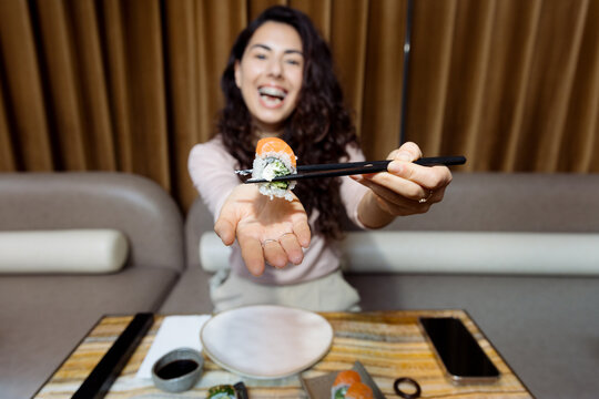 Young woman with braces eating sushi