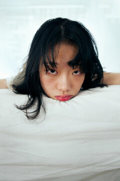 oft Portrait of a Young Asian Woman Resting on White Linens