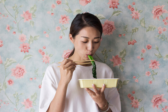 Eating Seaweed Against Floral Wallpaper