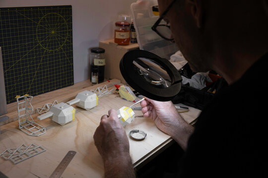 Man working on intricate hobby project at a work bench