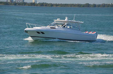 White sport fishing boat powered by three outboard engines.