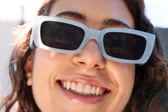 Young woman in blue sunglasses outside