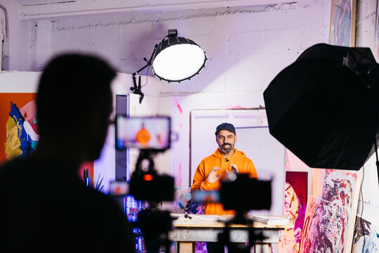 Visual artist speaking in front of cameras

