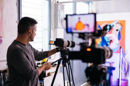 Cameraman adjusting tripod in studio

