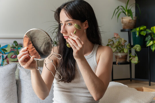 Woman Massaging Face With Jade Roller