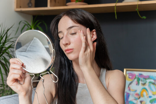  Woman Gently Touching Face In Mirror