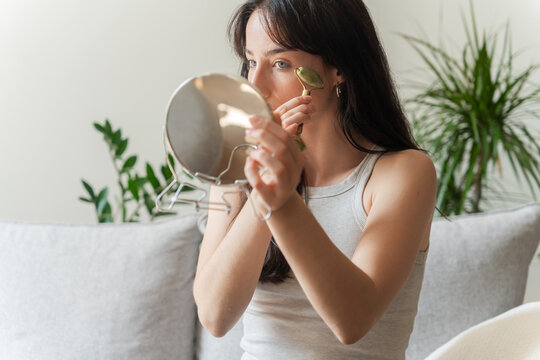 Woman Rolling Face With Jade Tool