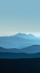 Obraz premium Majestic mountains bathed in the soft glow of a distant sunrise.