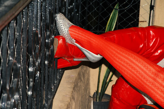 Two women&rsquo;s legs with red stockings and high heels