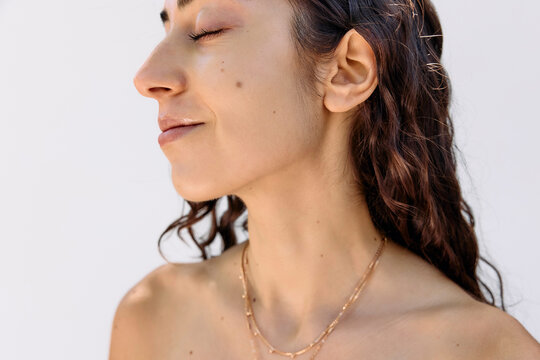 Young woman wearing a golden necklace outside 