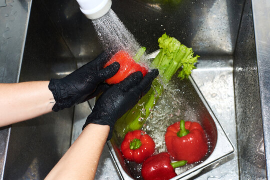 Washing fresh vegetables at a kitchen sink to prepare a meal