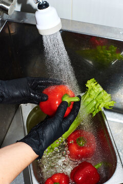 Washing fresh vegetables at a kitchen sink to prepare a meal