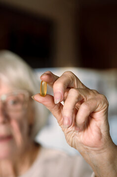 Elderly Woman Holding Softgel Vitamin Capsule