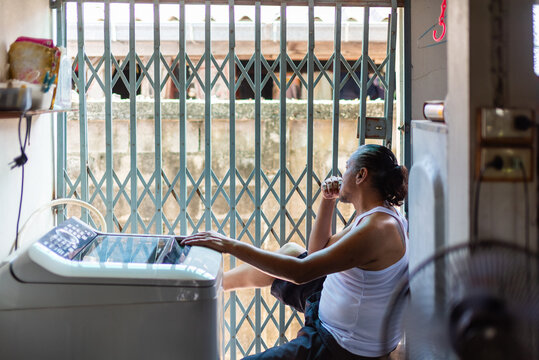 Elderly man doing laundry quietly behind his home, lost in thought