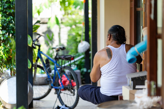 Elderly man sitting quietly behind his home in a moment of stillness