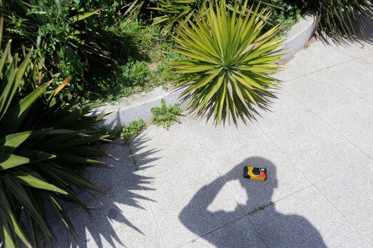shadow of a young man holding a disposable film camera