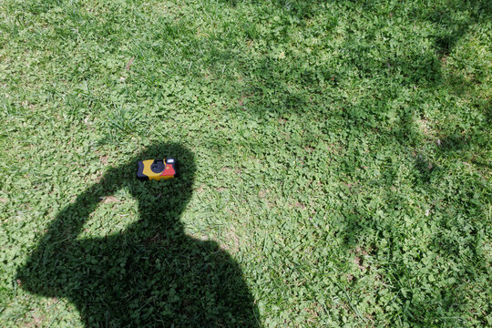 shadow of a young man holding a disposable film camera