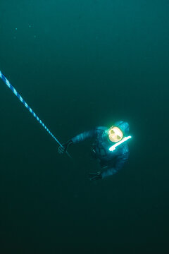 Freediver Ascending Along Rope in Cold Lake