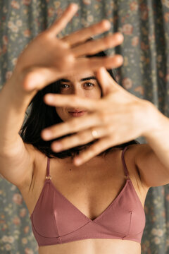 Woman smiling in mauve bra with raised hands