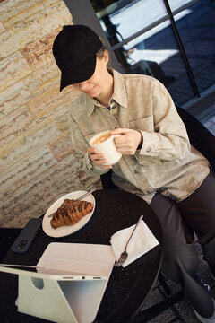 Enjoying coffee while working on a tablet at outdoors cafe
