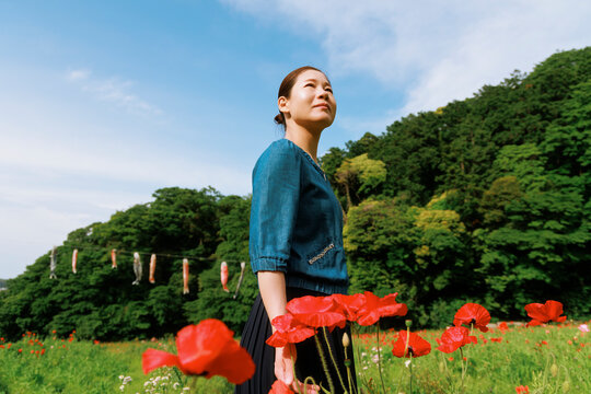 A woman in a field of Corn Poppies.