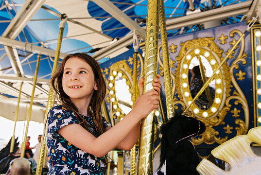 Happy child smiles while riding on a carousel