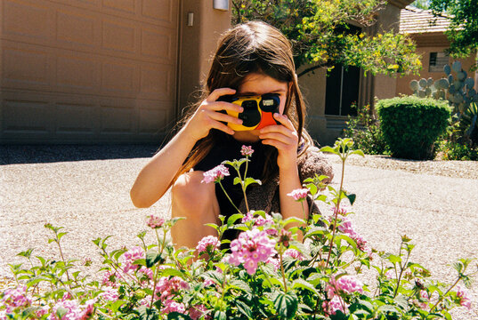 Child takes photo of flowers with disposable film camera