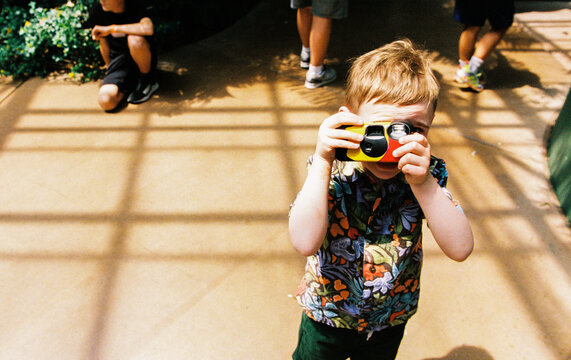 Child uses a disposable camera while on vacation