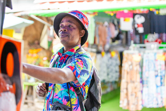 Tourist choosing colorful shirt at street market in Thailand