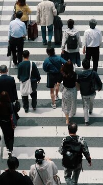 Busy pedestrian crosswalk with crowd crossing the street in Osaka.