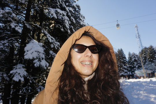 Portrait of a young woman in a winter forest at a ski resort